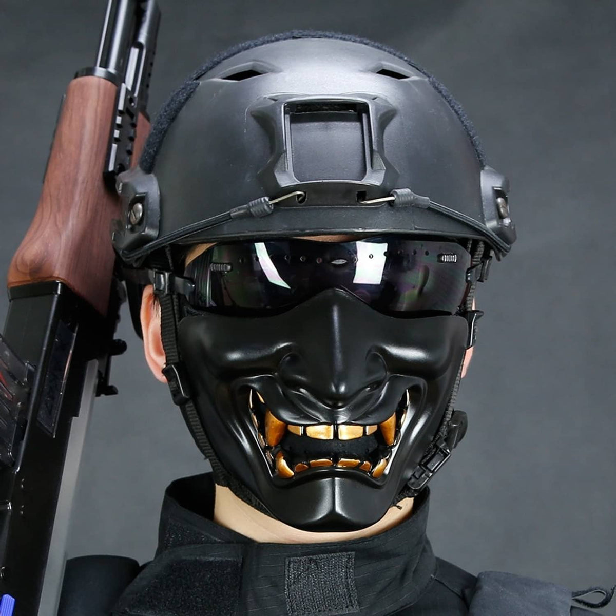 Black demon half-face mask with gold teeth worn under tactical helmet
