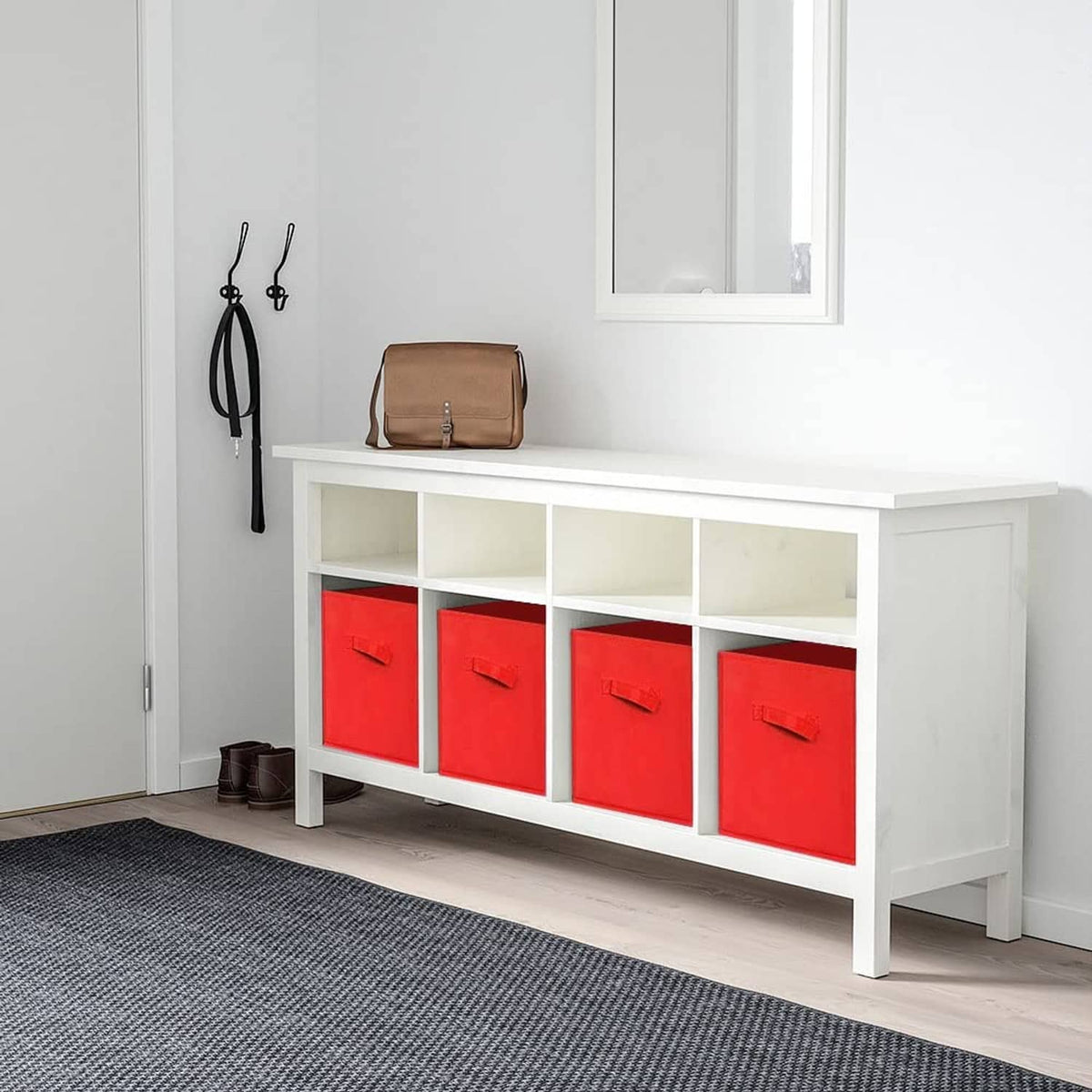 Red fabric storage cube bins with front handles arranged in a white console