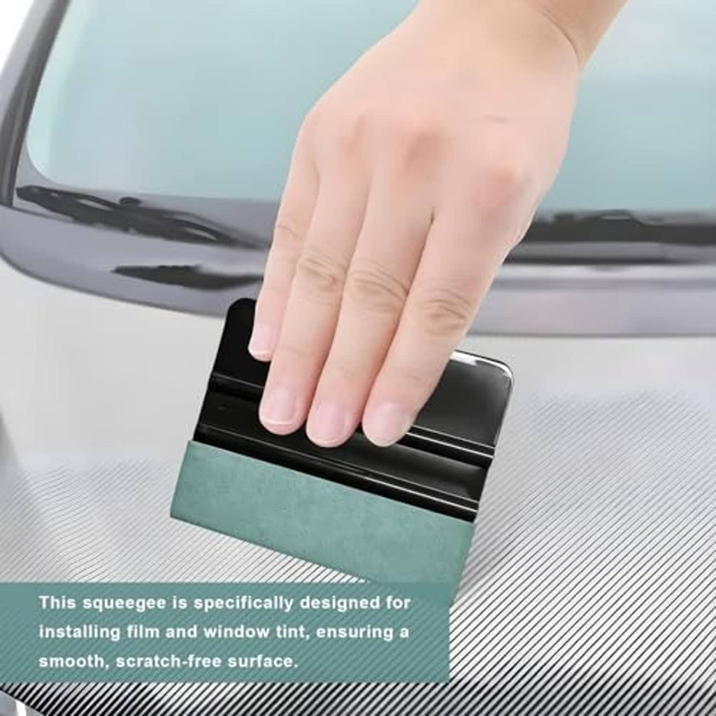 Car window tint squeegee with teal felt pad pressed onto film on a car window