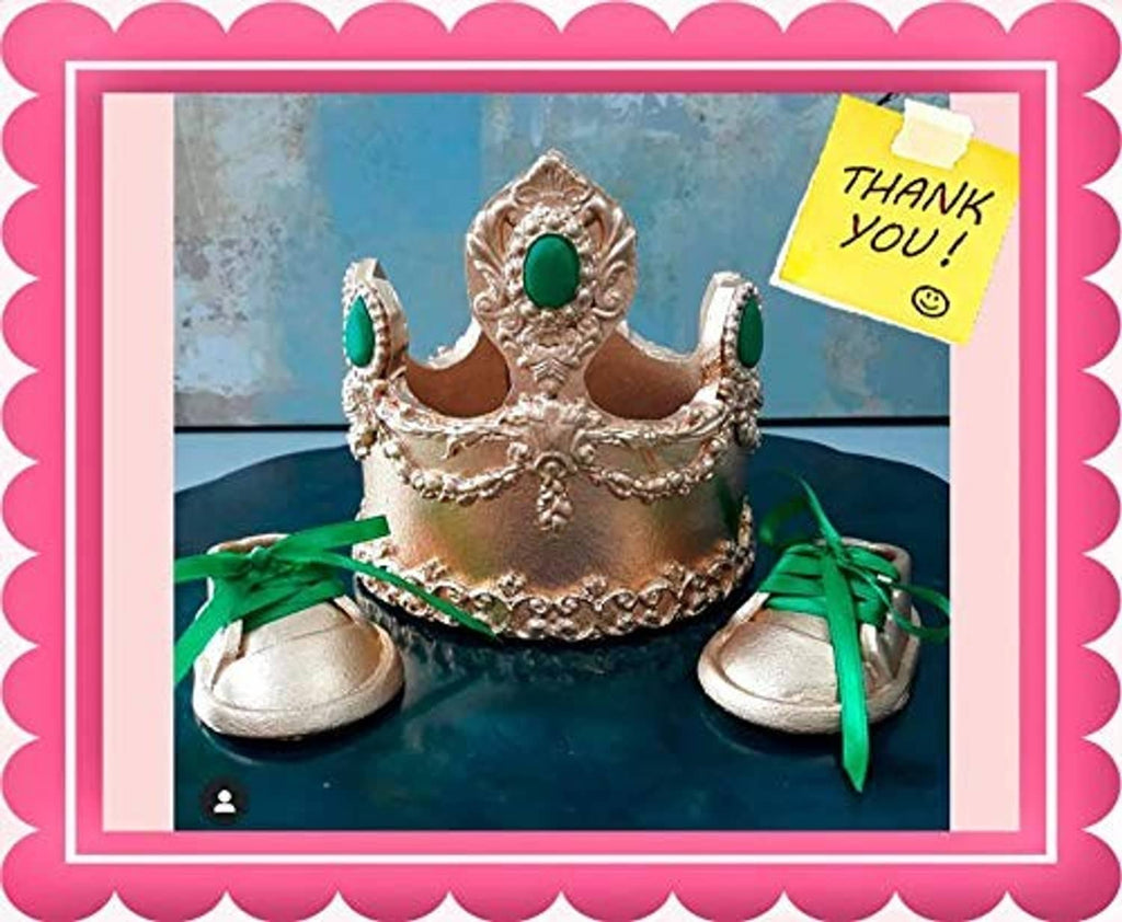 Gold glitter tiara crown on blue cake with green ribbon accents