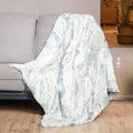 Light blue and white faux fur heated throw blanket, draped over seating