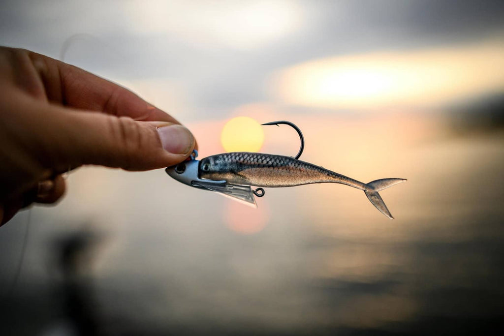 Silver shiner minnow soft lure held up by the hook, side view