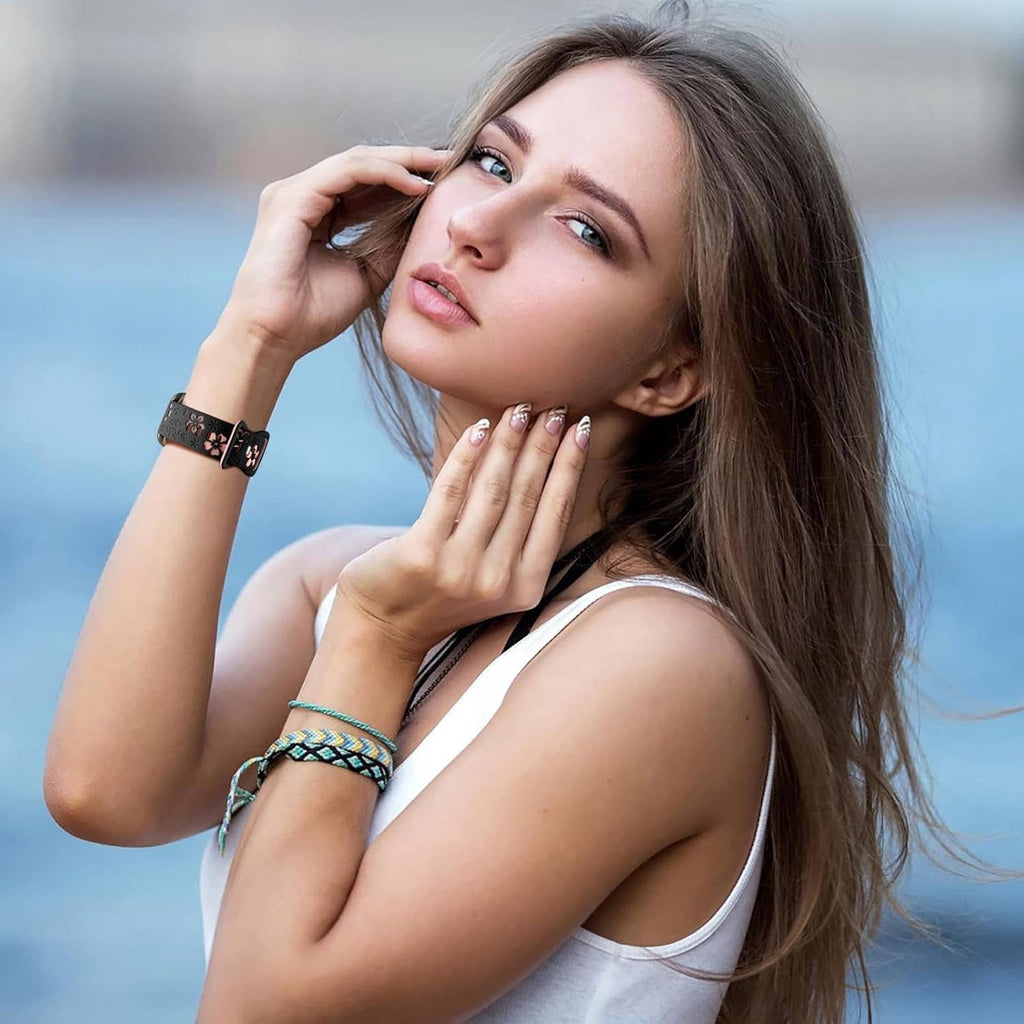 Floral engraved smartwatch band in black with pink flowers worn on woman’s wrist