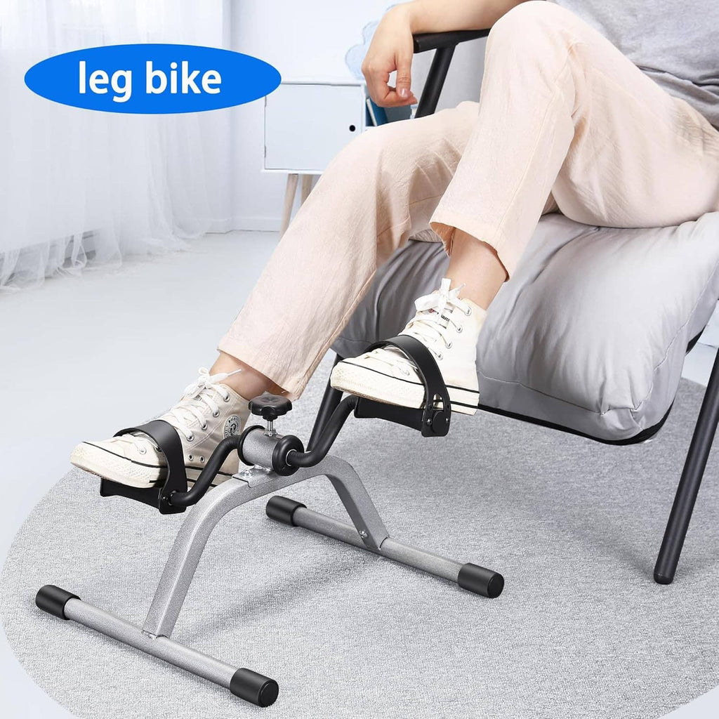 Mini exercise pedal bike on couch for leg workouts with feet on black pedal plates