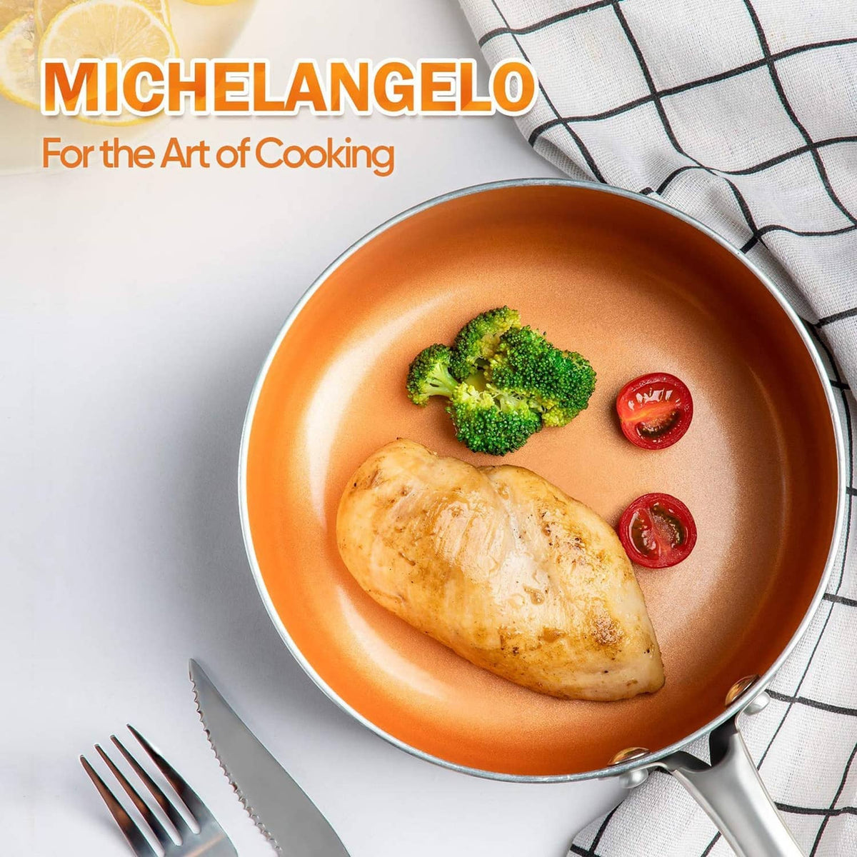 Orange nonstick frying pan with chicken, broccoli, and cherry tomatoes, stainless handle