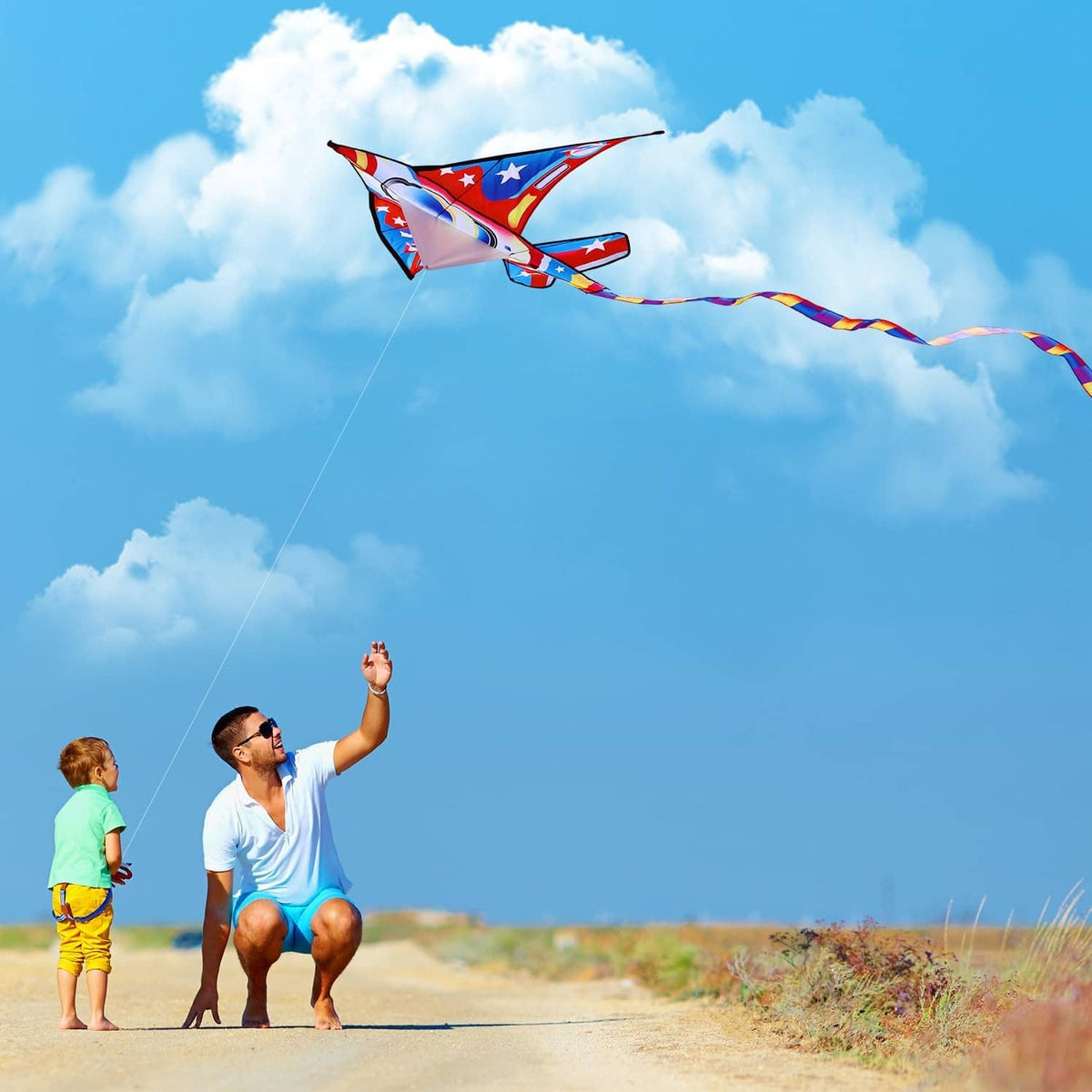 Airplane kite flying in the sky, red and blue star design with long tail line