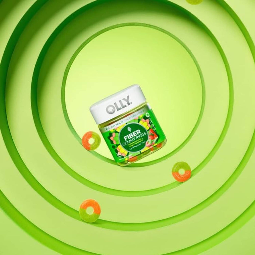 OLLY Fiber Gummy Rings bottle pictured on green circular graphic with orange gummy pieces.