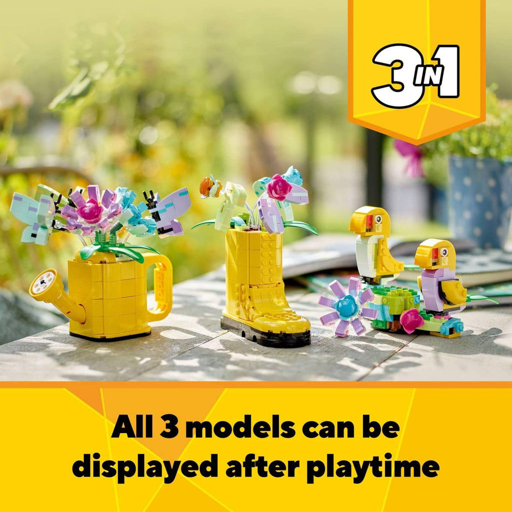 Three LEGO Creator flower watering can models with bright multicolor flowers