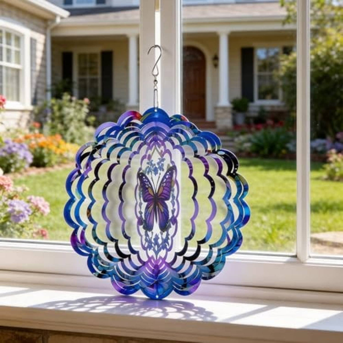 Metal butterfly wind spinner with blue and purple layered discs, hanging by a silver chain near a window.