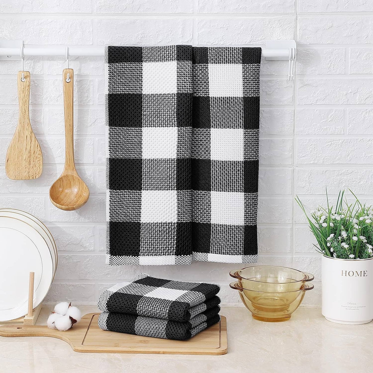 Black and white check waffle weave kitchen towels stacked on a tray