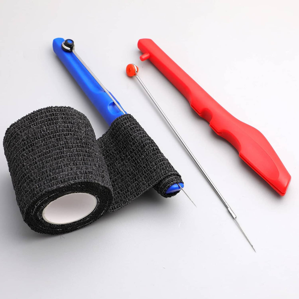 Red and blue tattoo poke-a-stick tools with black grip tape rolls and needle tips