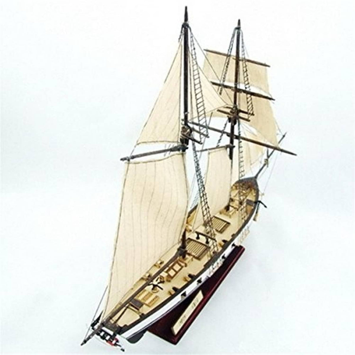 Wooden sailboat model from side view with tall masts and rigging