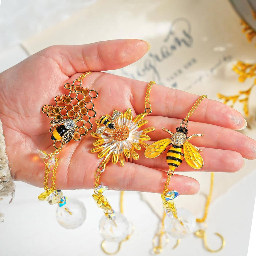 Close-up of gold bee and flower crystal suncatcher charms with faceted dangling beads