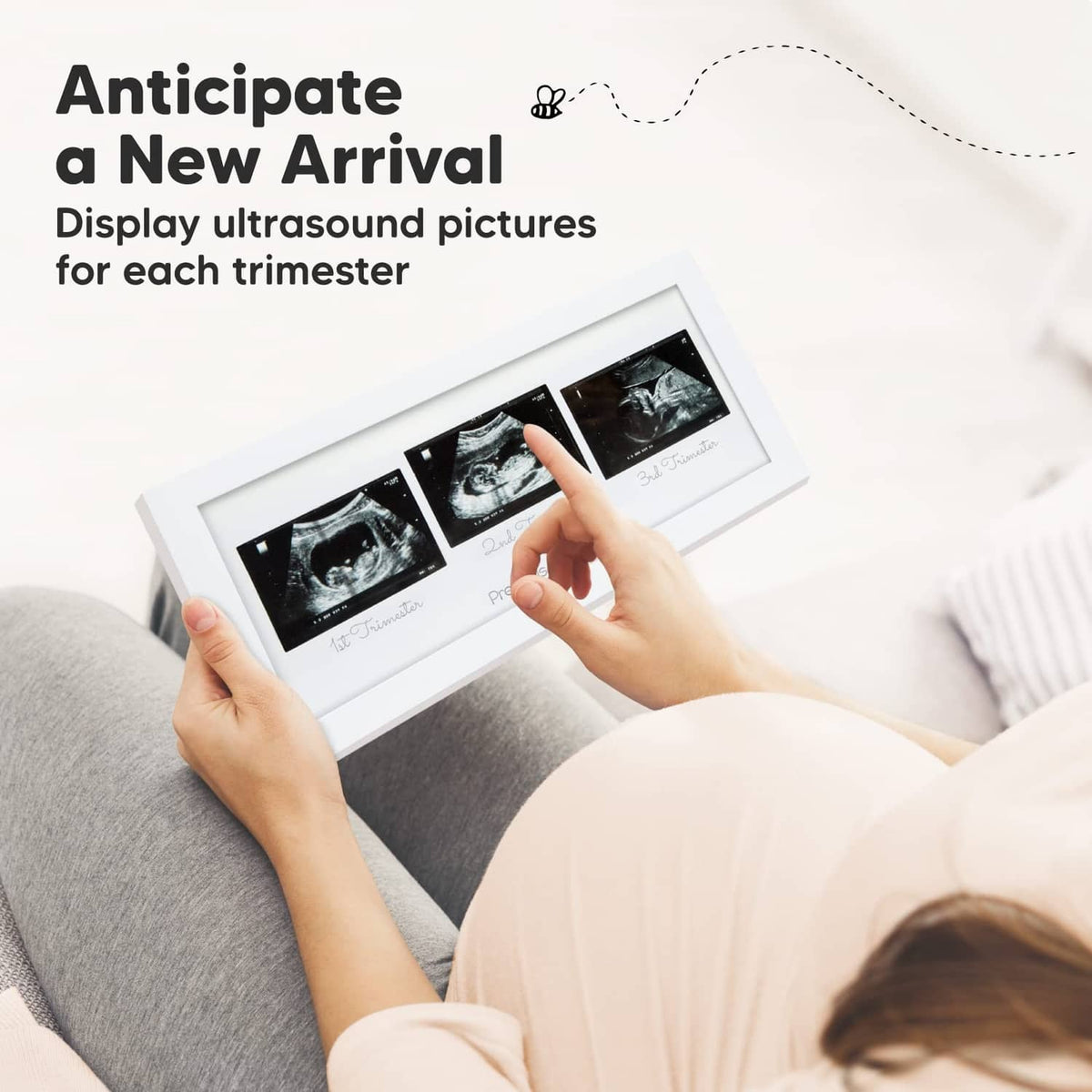 Hands holding a white ultrasound trio picture frame showing three sonogram images