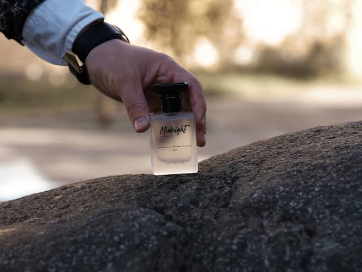 Hand applying cologne from a small spray bottle