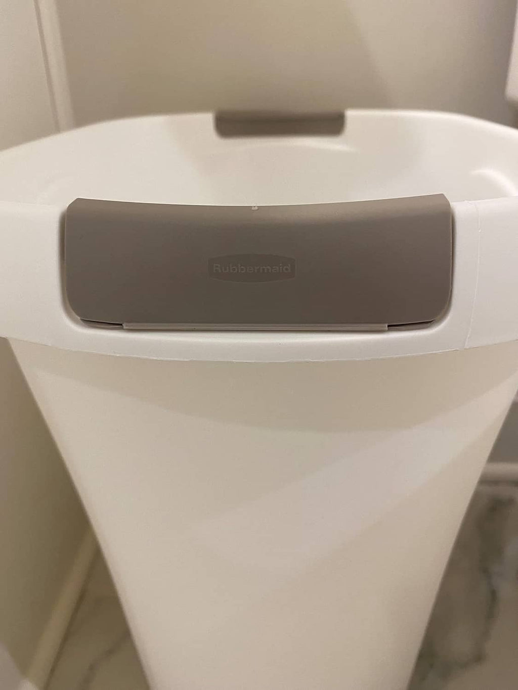 Gray swing lid on a white Rubbermaid open-top trash can