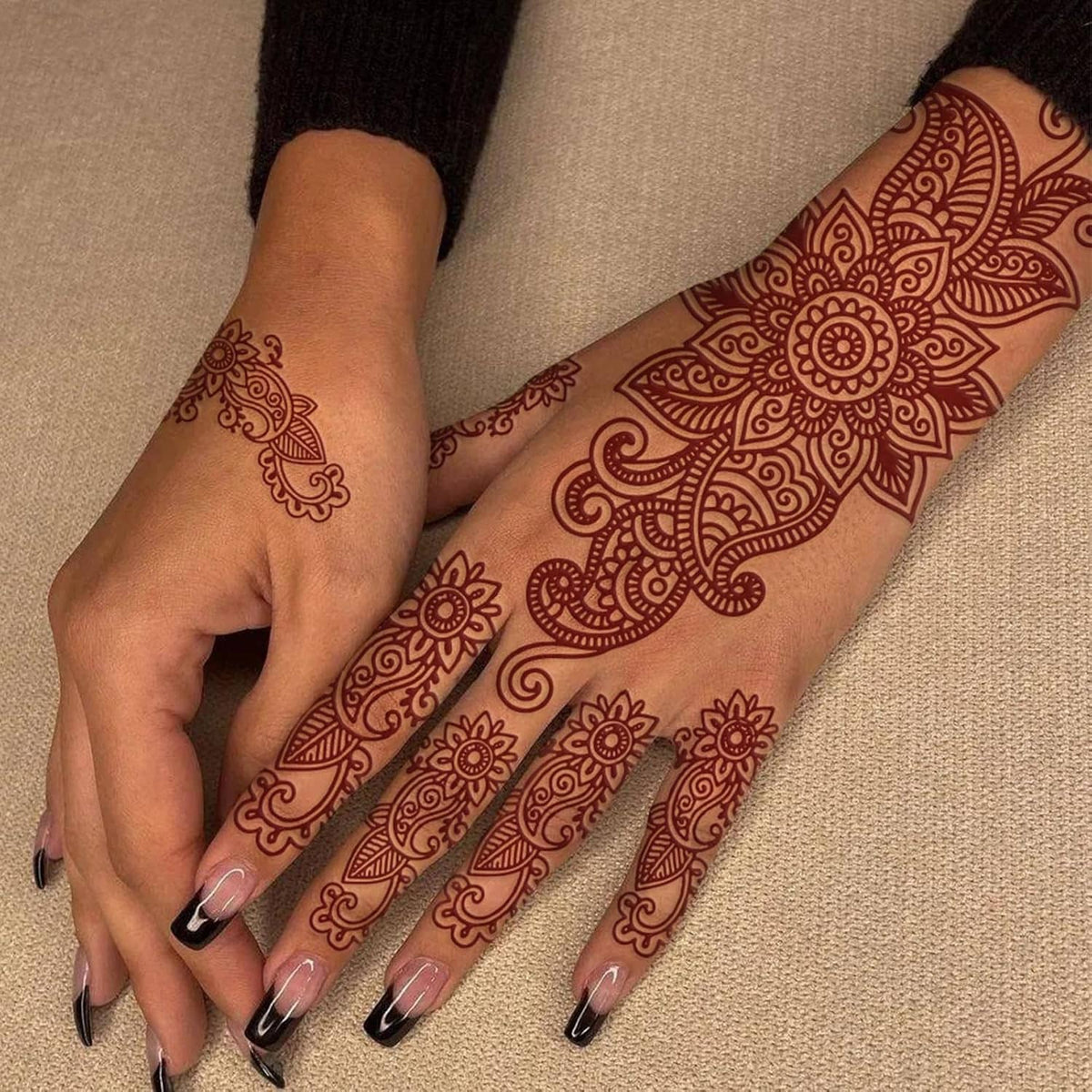 Brown henna-style fake tattoo on hands with ornate floral paisley pattern