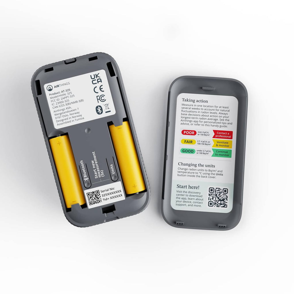 Back view of black digital radon detector with battery compartment and labels