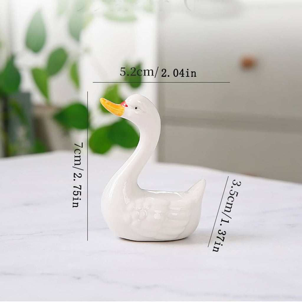 White ceramic swan figurine with orange beak, angled side view