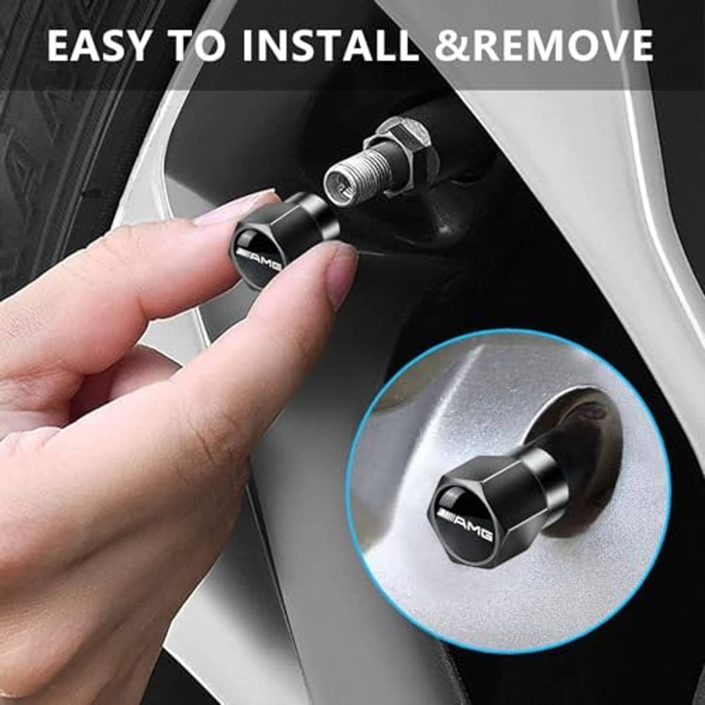 Black metal tire valve stem cap with AMG emblem being installed by hand on wheel
