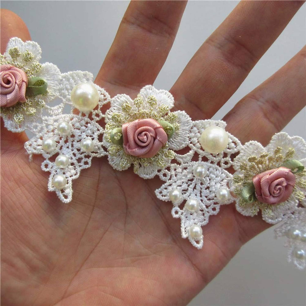 White lace trim with pink roses and pearl beads held in hand for size
