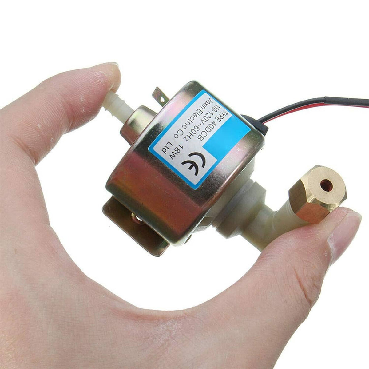 Oil pump for fog machine held in hands, showing blue label and outlet fittings