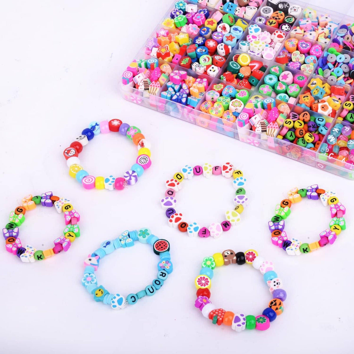 Colorful polymer clay charm bead bracelets laid out with alphabet and fruit beads