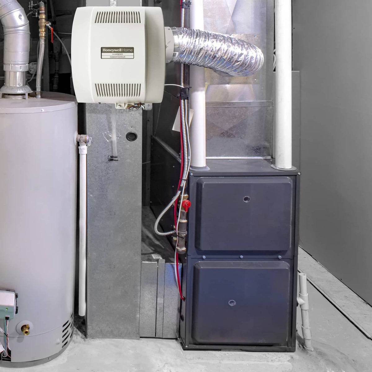 Whole-home humidifier installed with connected duct hose and control unit housing