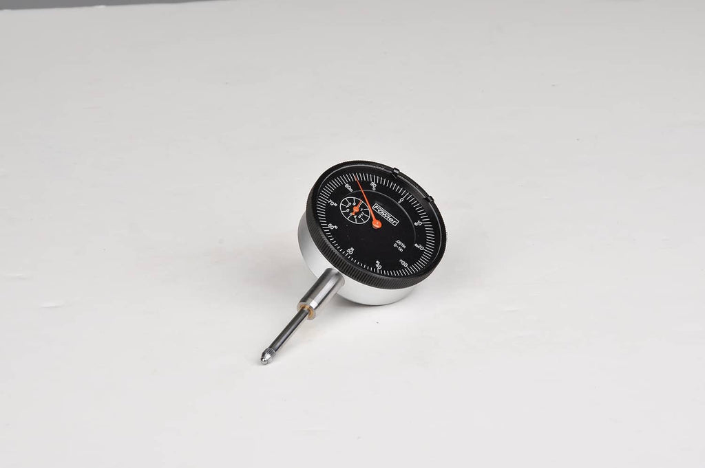 Compact dial indicator with black dial, orange pointer, and metal contact tip