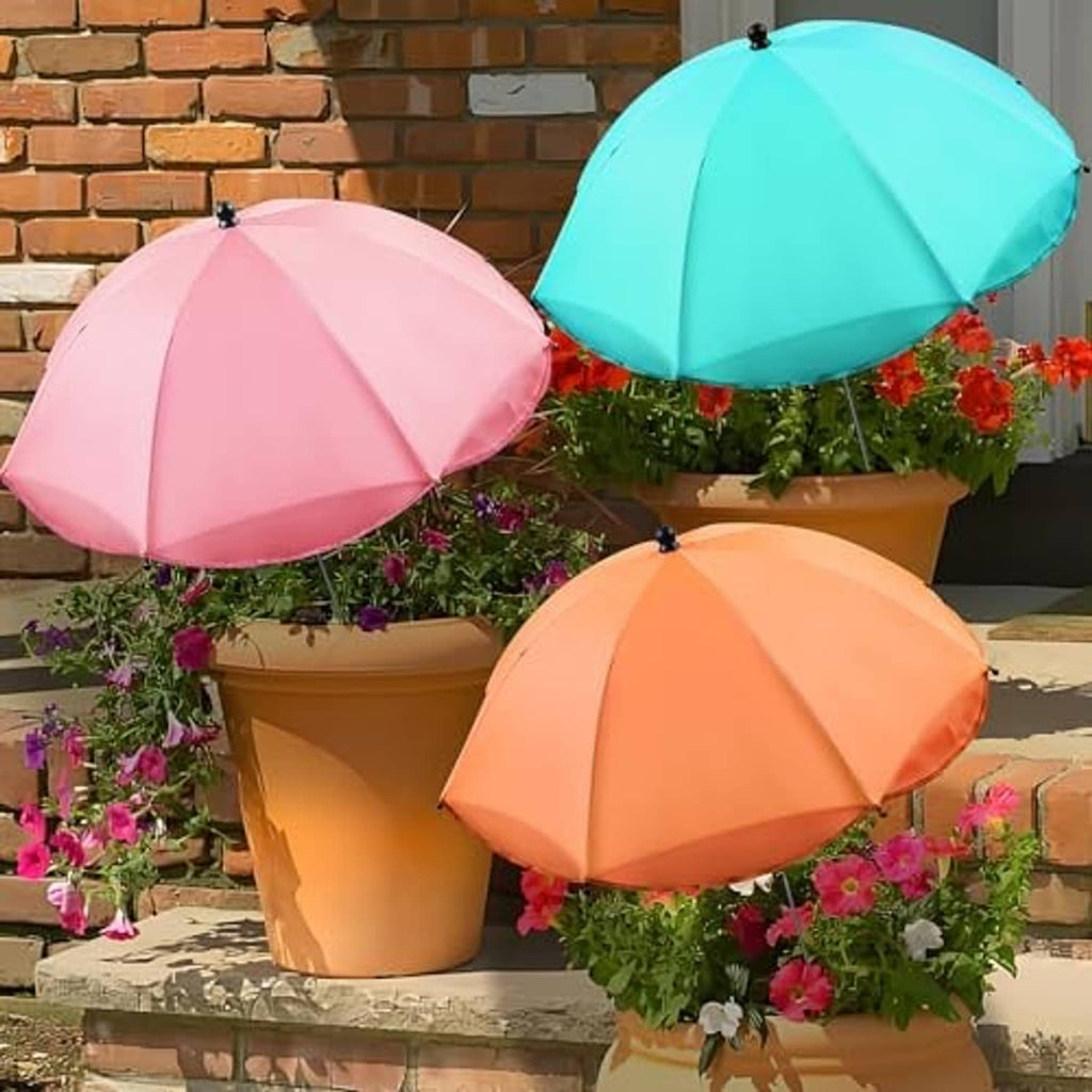 Set of three adjustable plant sunshade umbrellas in pink, teal, and orange over planters