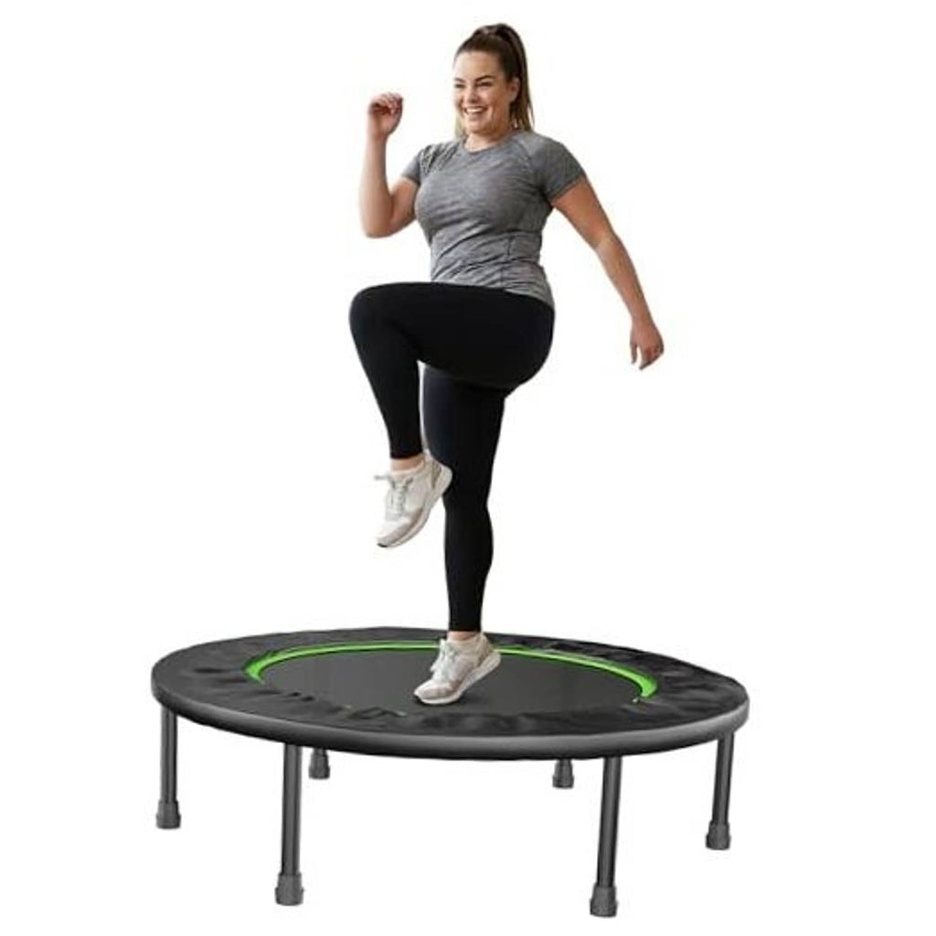 Mini fitness trampoline with dark round deck and green edge, person jumping
