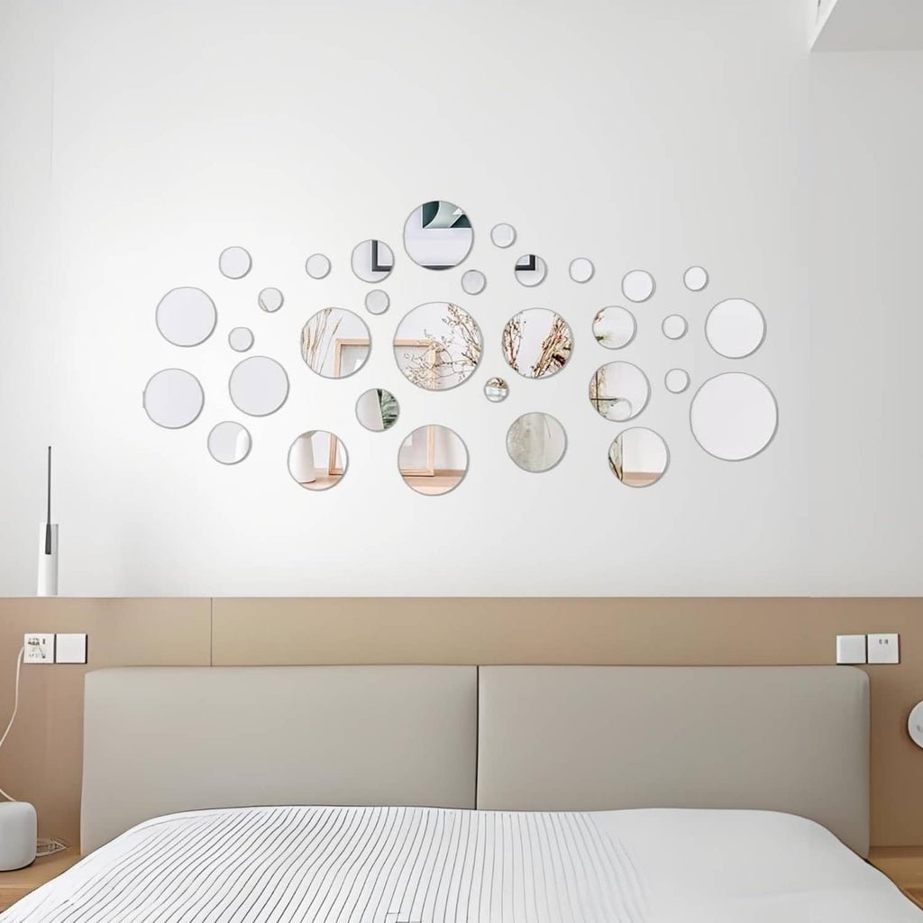 Wall arrangement of silver circular acrylic mirror tiles in a scattered cluster