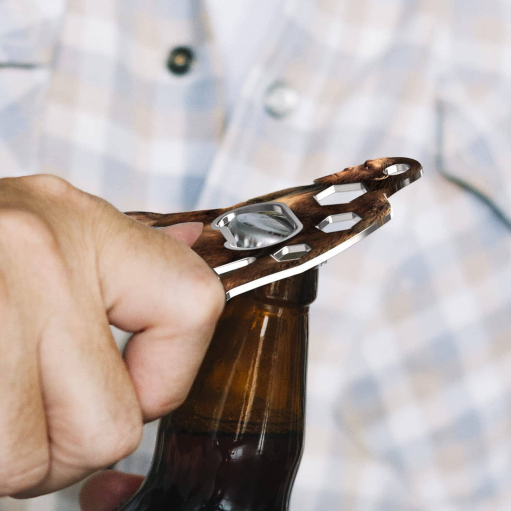 Sasquatch multi-tool held in hand removing bottle cap with integrated opener