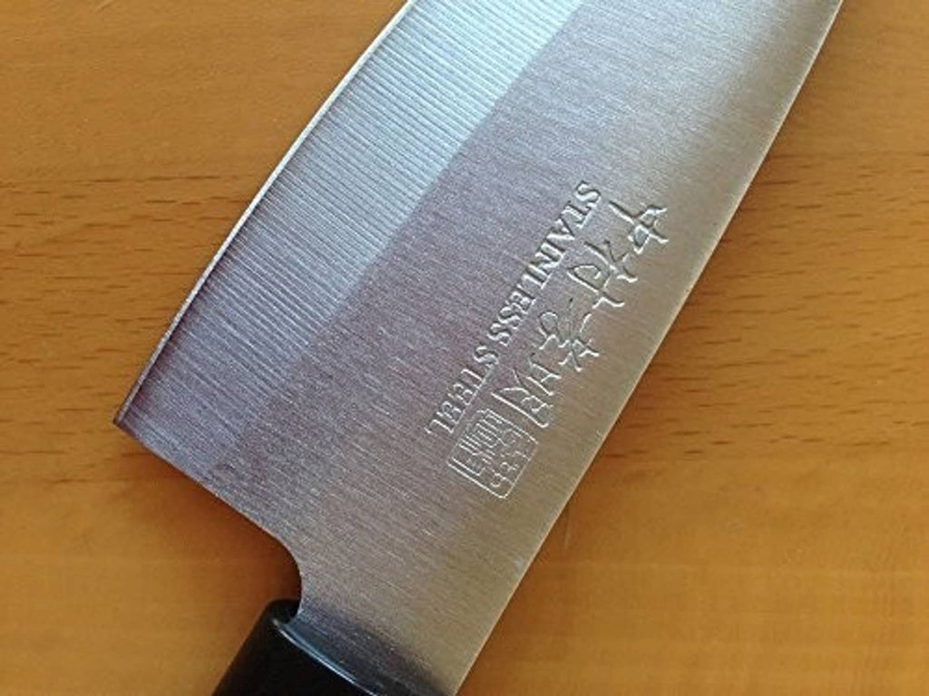 Japanese kitchen knife blade with etched markings and dark handle end