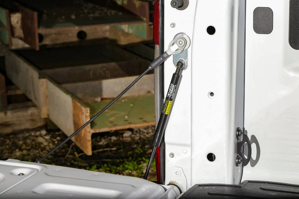 Tailgate assist rod and brackets on white truck bed side