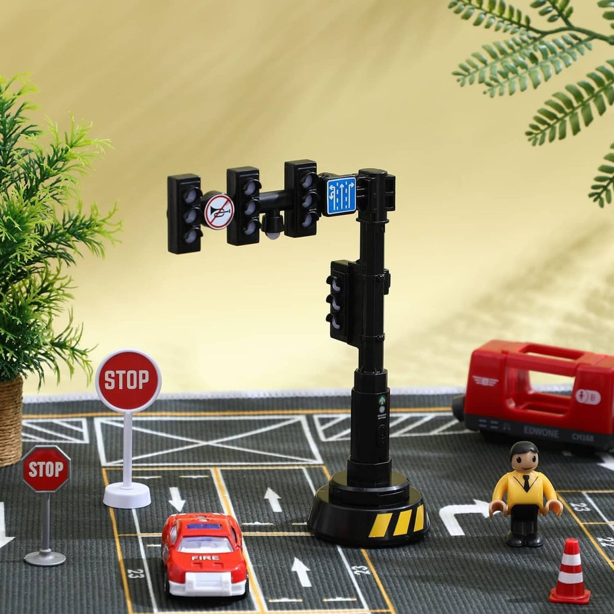Black traffic light model on a round base with small road accessories and toy cars