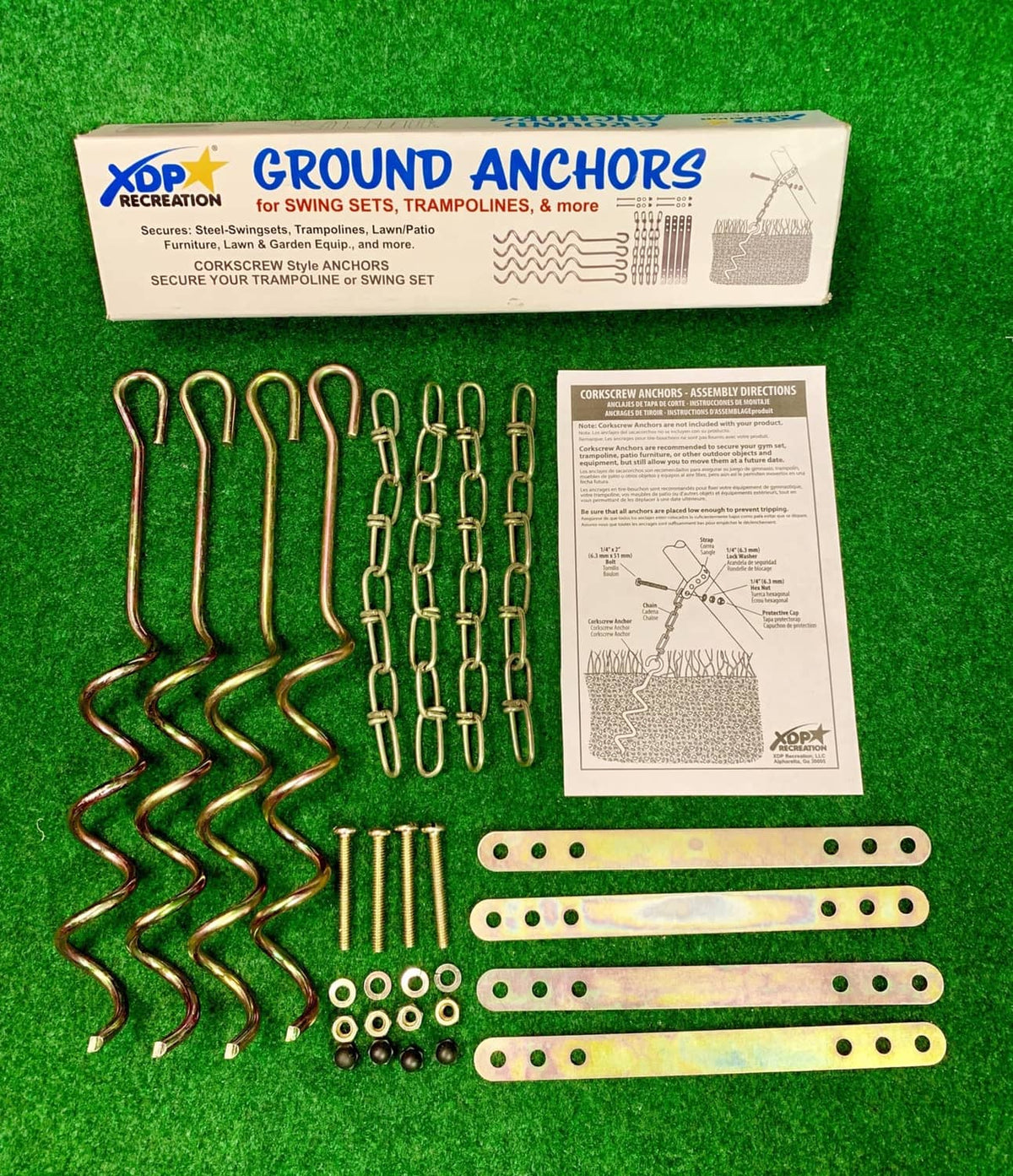 Ground anchor kit on grass: spiral stakes, chain links, and mounting plates