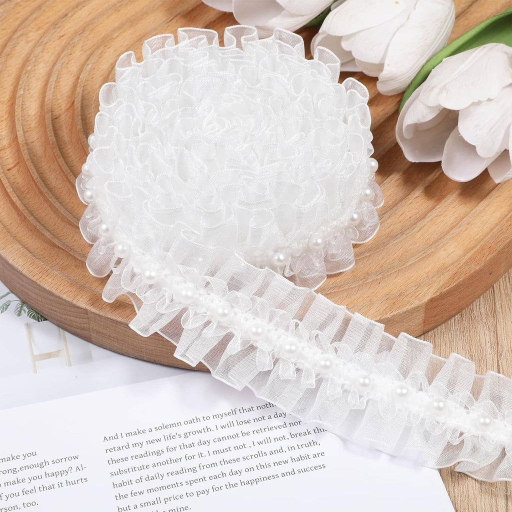 White pearl lace ruffle trim with layered scallops and bead row, coiled on wood
