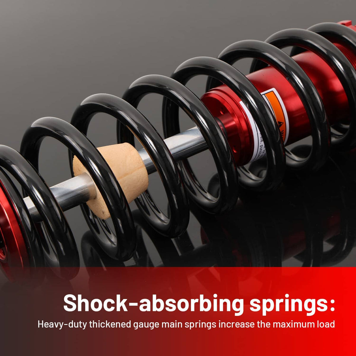 Close-up of black coil shock springs around red cylinders with ribbed spring covers