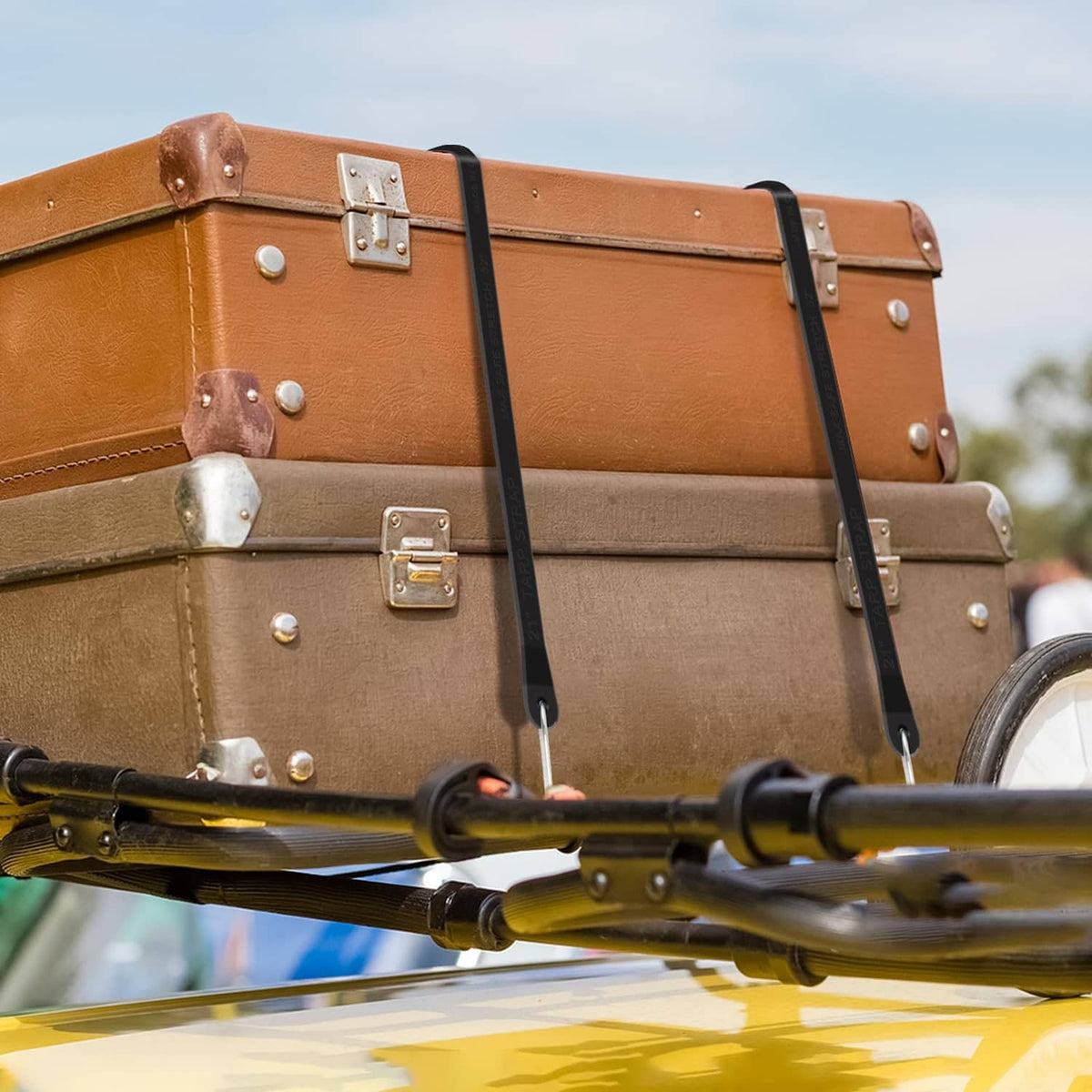 Black bungee tie straps with metal hooks securing a luggage rack