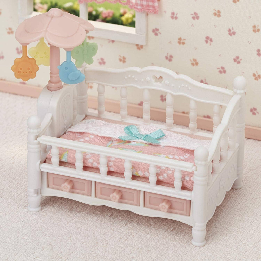 White dollhouse crib with pink bedding and canopy mobile with animal and star charms