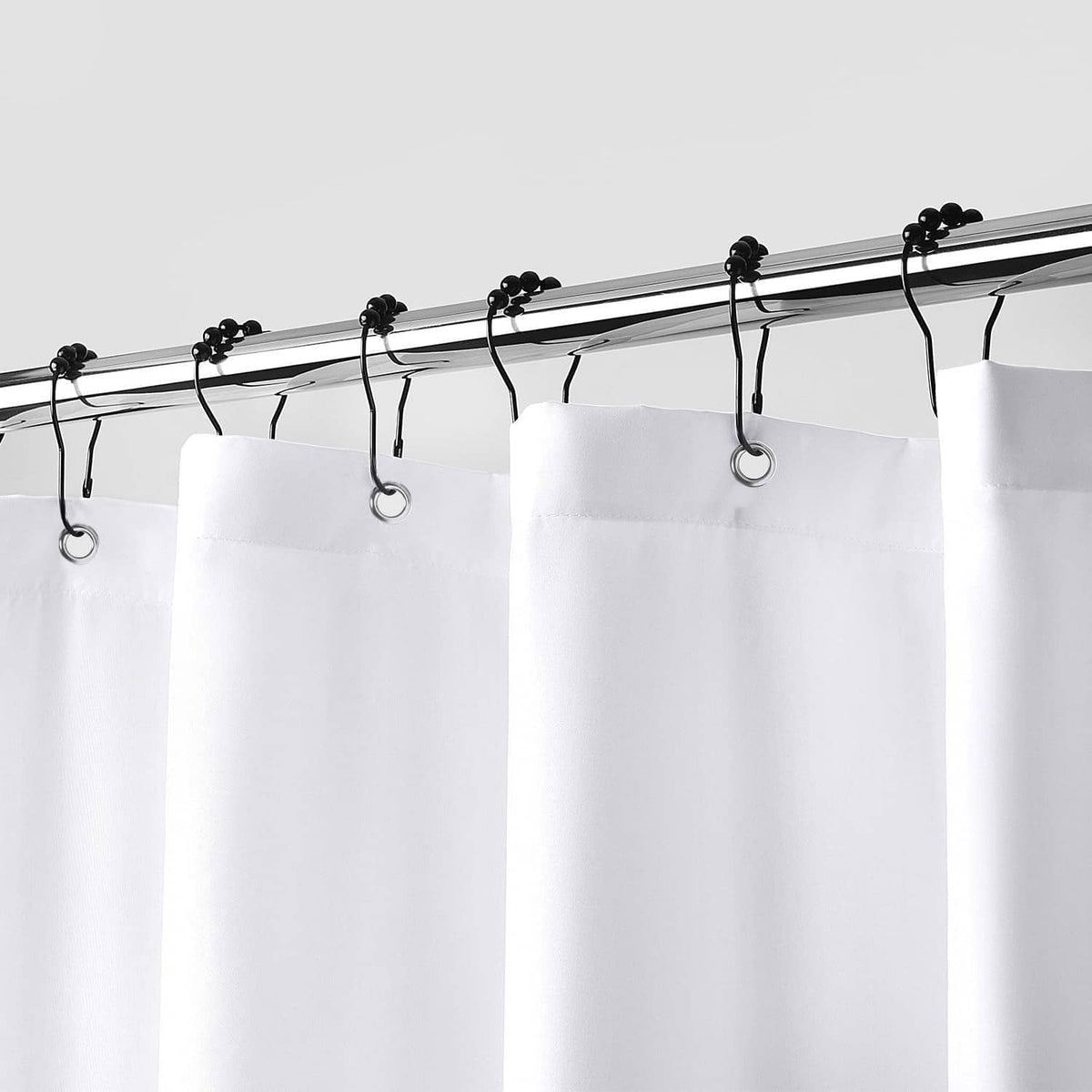 White shower curtain liner with multiple grommets and hanging rings on rod