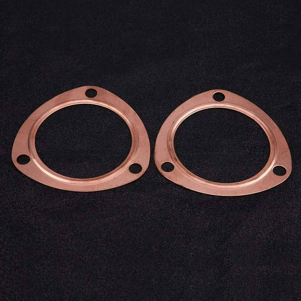 Pair of copper exhaust header gasket flanges on dark surface, bolt holes visible
