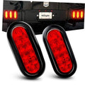 Two oval red LED trailer tail lights mounted on vehicle rear, illuminated