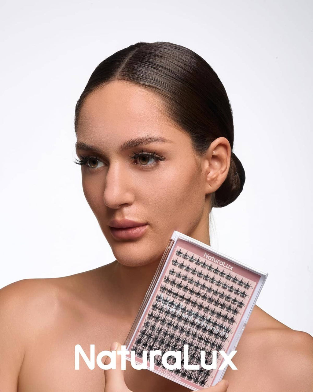 Model holding a clear pink lash case with wispy false eyelash strips