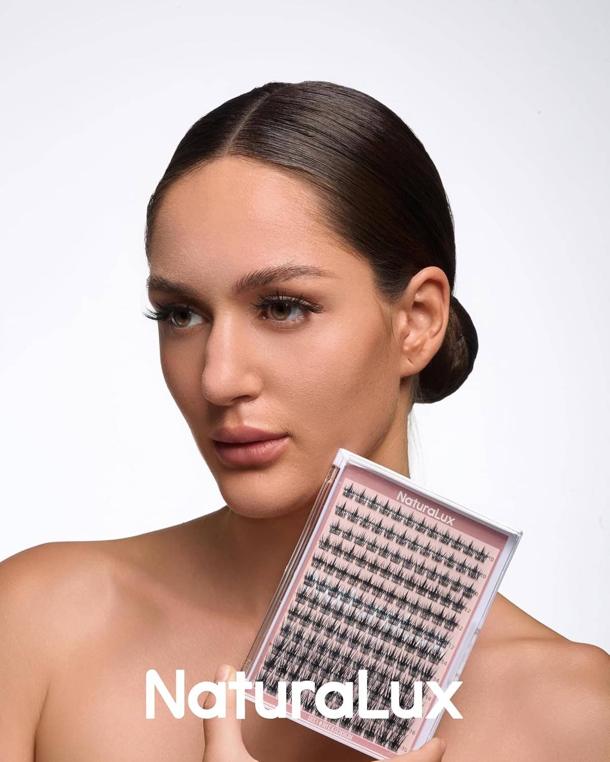 Model holding a clear pink lash case with wispy false eyelash strips