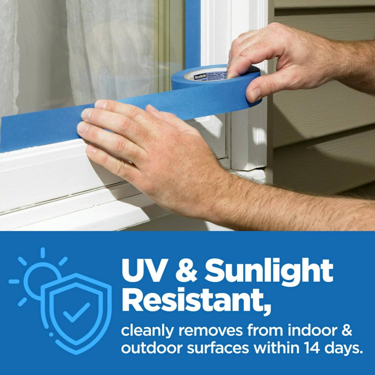 Hand applying blue painter's tape to window trim with UV and sunlight-resistant mark