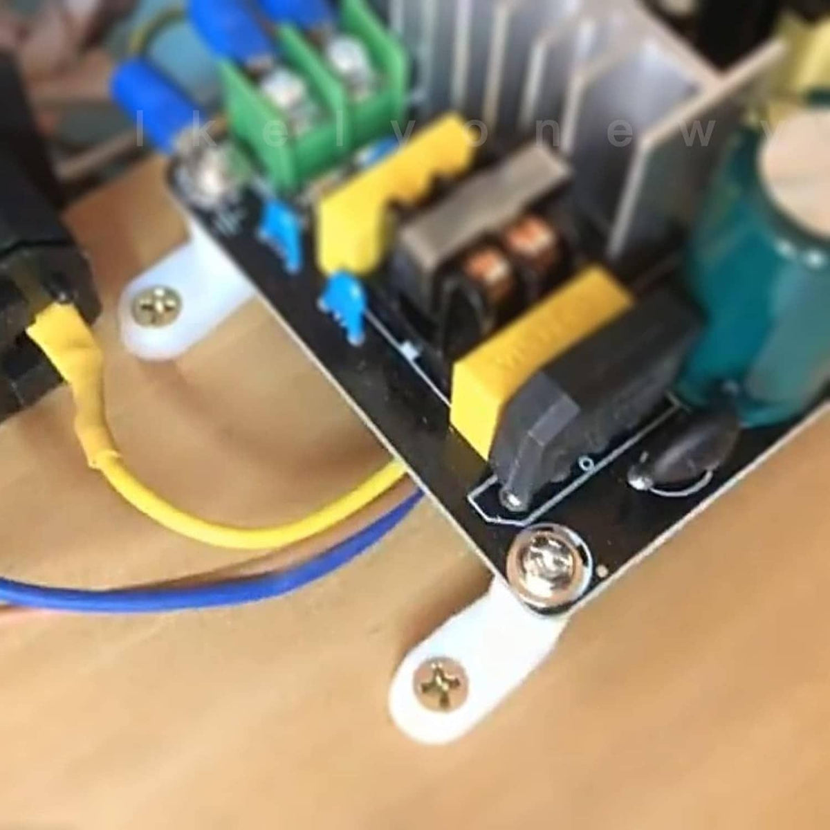 White plastic motherboard standoff with brass insert and mounting screw on PCB