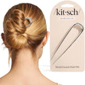 Silver metal French hair pin securing a low bun updo on brown hair