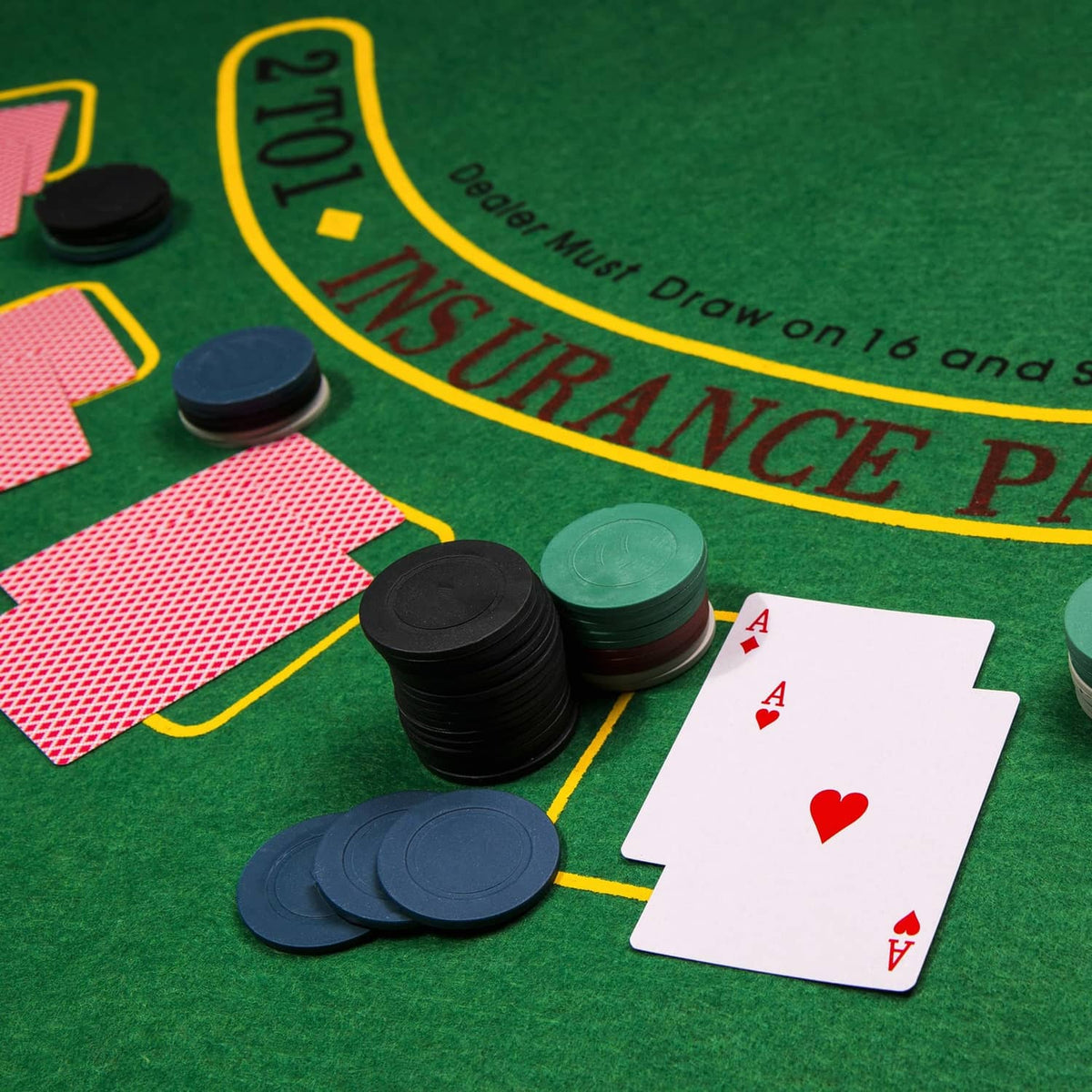 Roulette table felt with chip stacks, roulette ball pieces, and playing cards near wheel